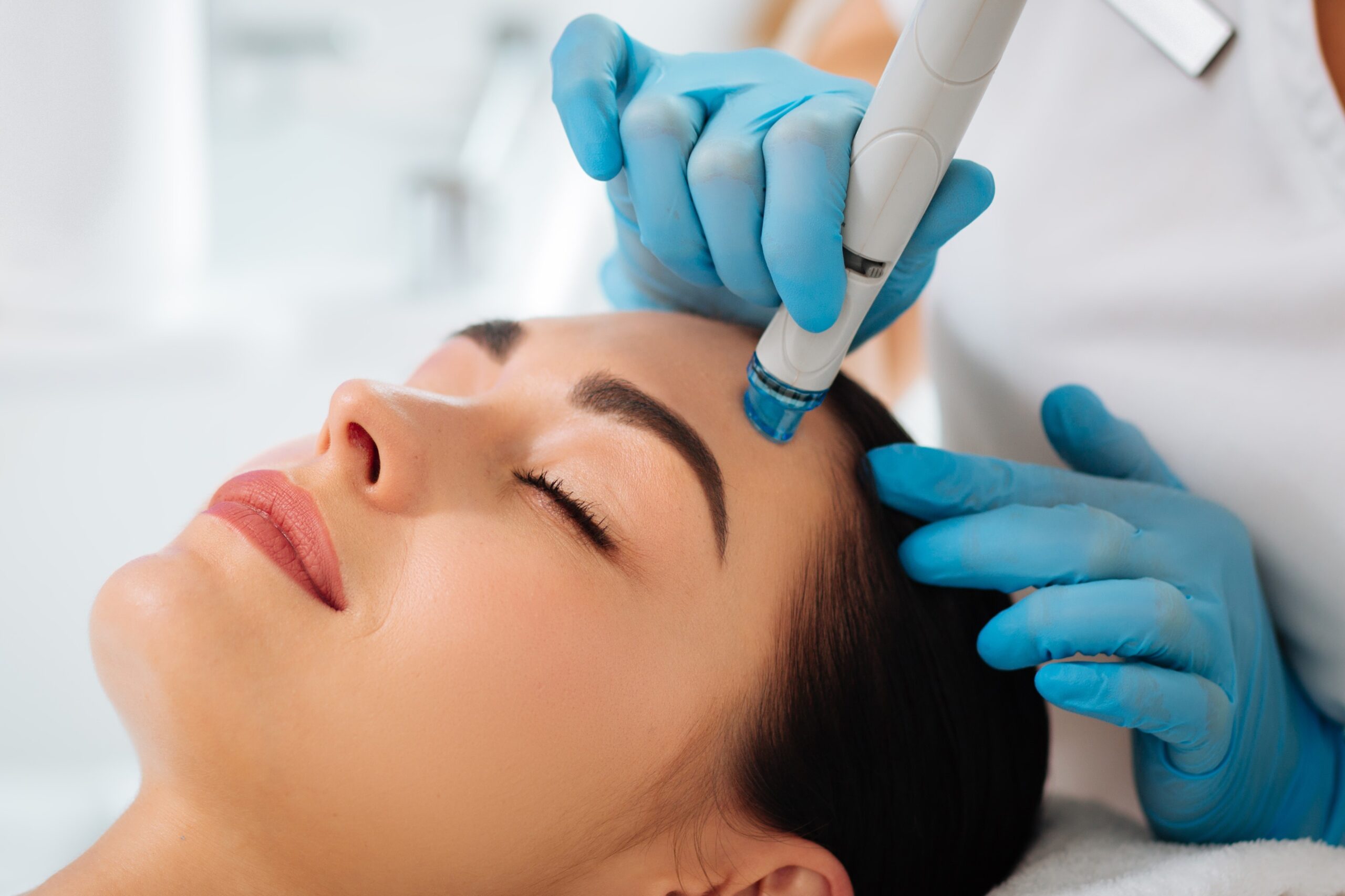smart skilled female cosmetologist using modern device